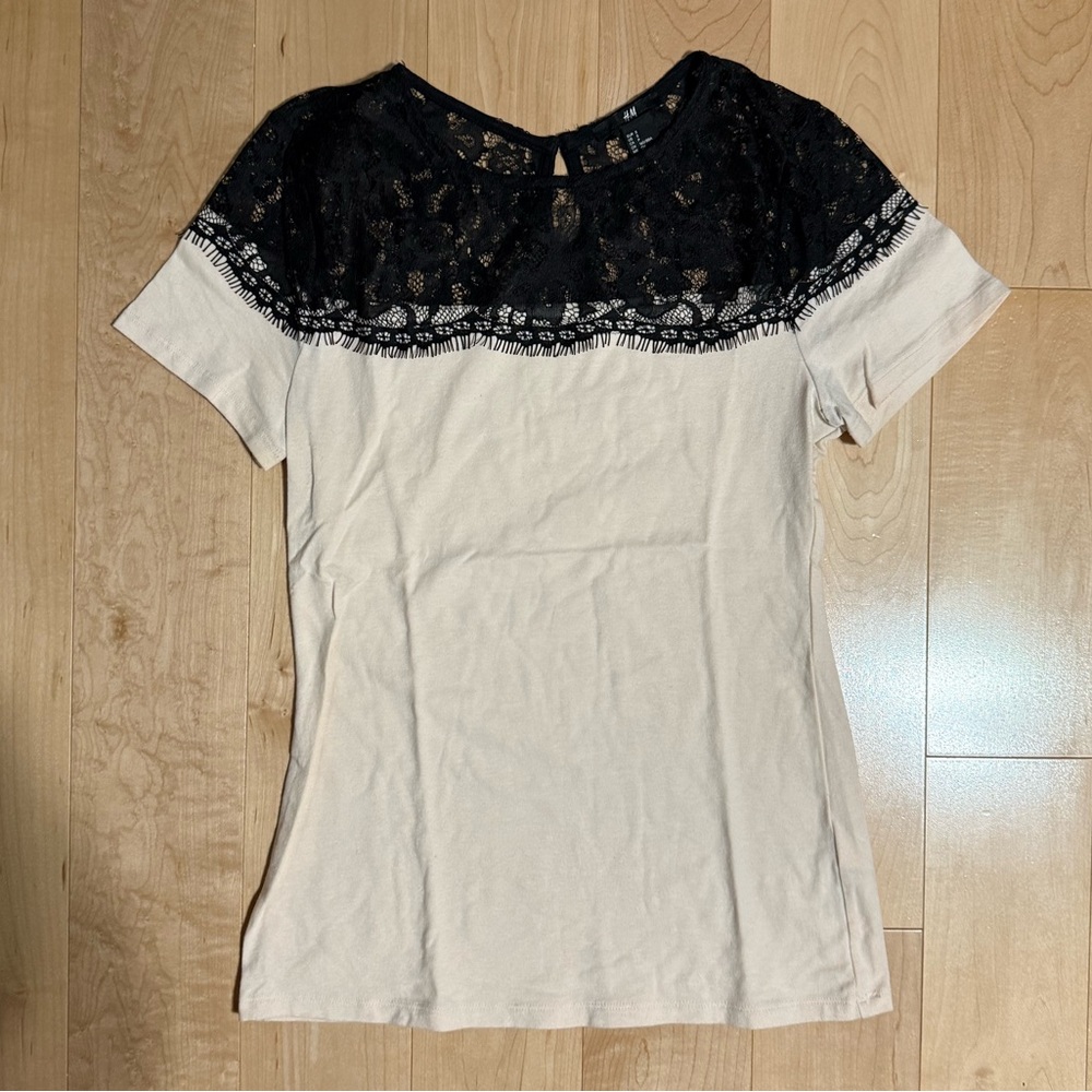 Light pink t shirt with black lace detail.